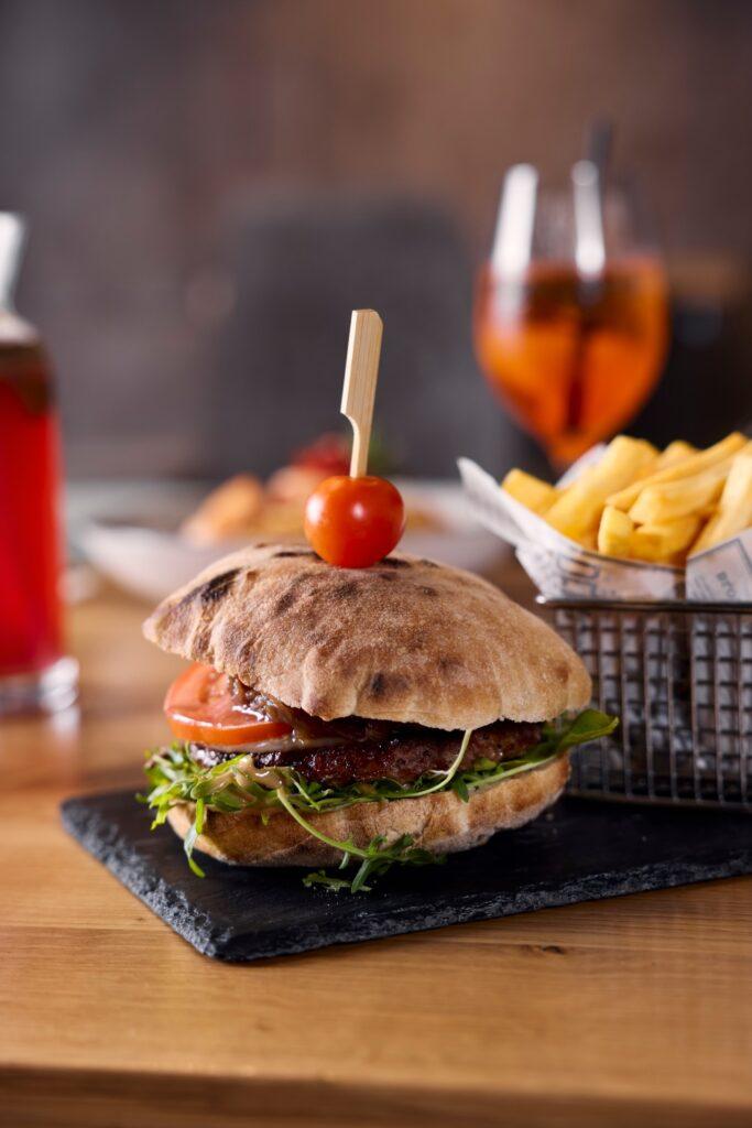 Saftiger Burger mit frischen Zutaten auf einem Holztablett