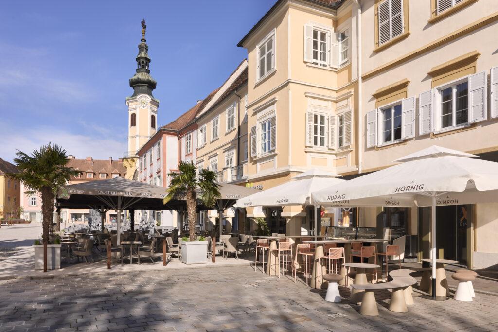 Charmante Caféterrasse mit Blick auf historischen Turm in einer malerischen Stadt