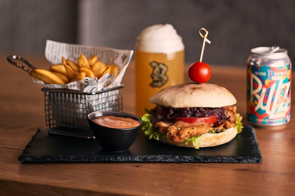 Saftiger Burger mit Pommes und Getränk auf einem Tisch